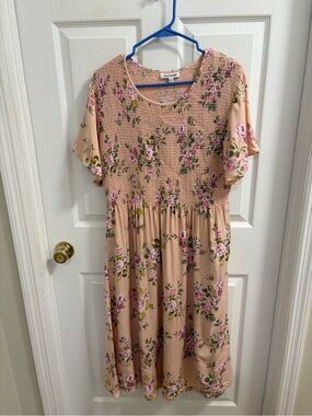 Serengeti peach-colored midi dress with a floral print and a smocked bodice.